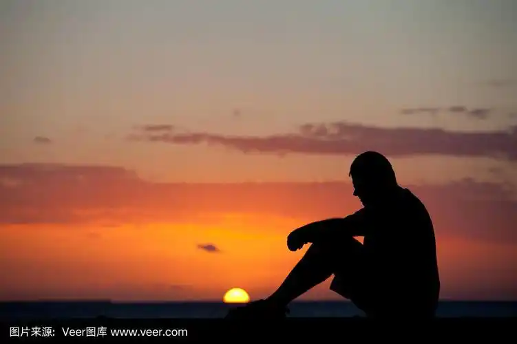 夕阳下坐着的男人的剪影