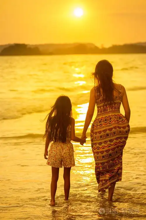 母亲和女儿站在沙滩上
