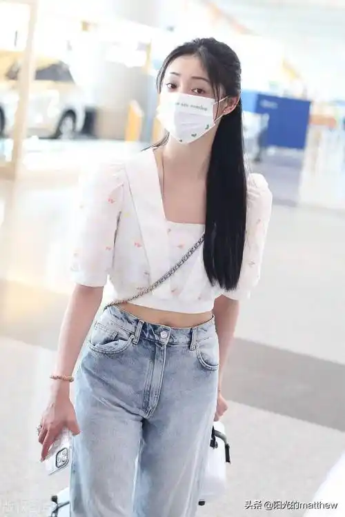 周洁琼白色露脐上衣牛仔裤现身机场长发披肩温柔尽显