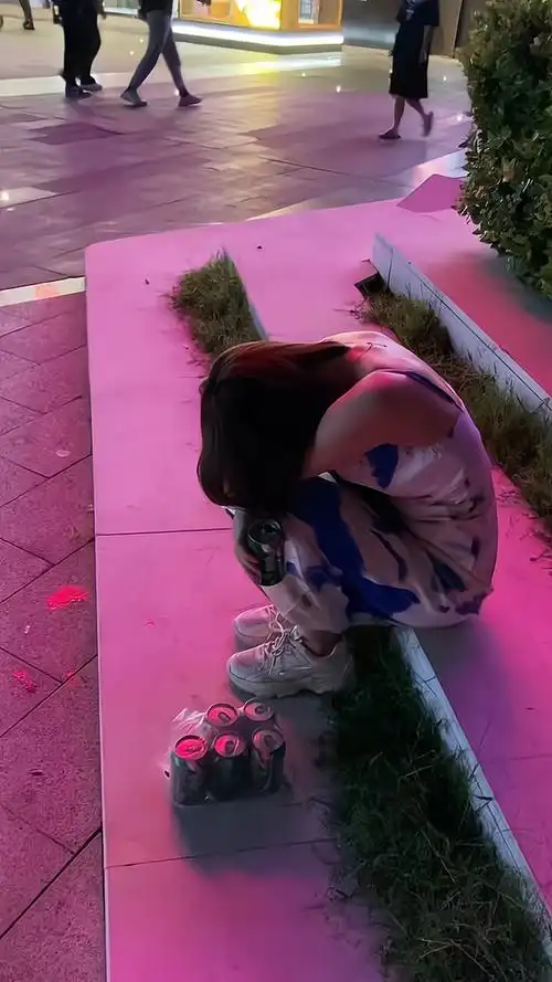 一女子找不到工作心情不愉快独自坐在马路边喝啤酒