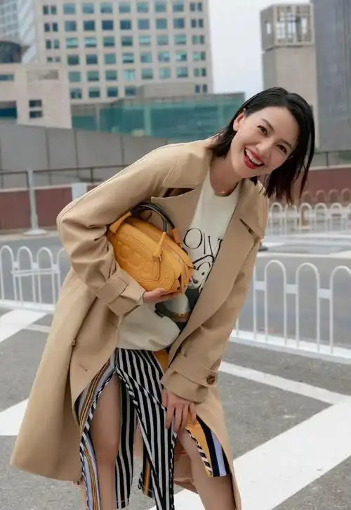 高圆圆穿卡色风衣内搭卫衣配拼色开叉半身裙,知性减龄,气场十足