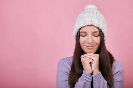 可爱的绝世女孩双手合十放在下巴下,靠在上面,微微一笑.照片