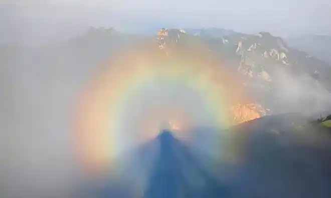 媒体都是这么写,某日在某地某座山上出现了佛光奇观.