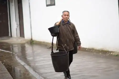 路上也会撞见要去田里施肥的农民伯伯,穿着雨靴,挑着皮桶,朝着田间