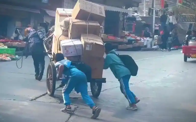 残疾大叔推车艰难上坡,2小男孩立马助力,学校予以全校通报表扬!