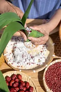 端午节户外奶奶包粽子特写图片