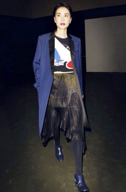 这张照片中王菲里面穿着一件印花的套头毛衣,外面搭配了一件蓝色的长