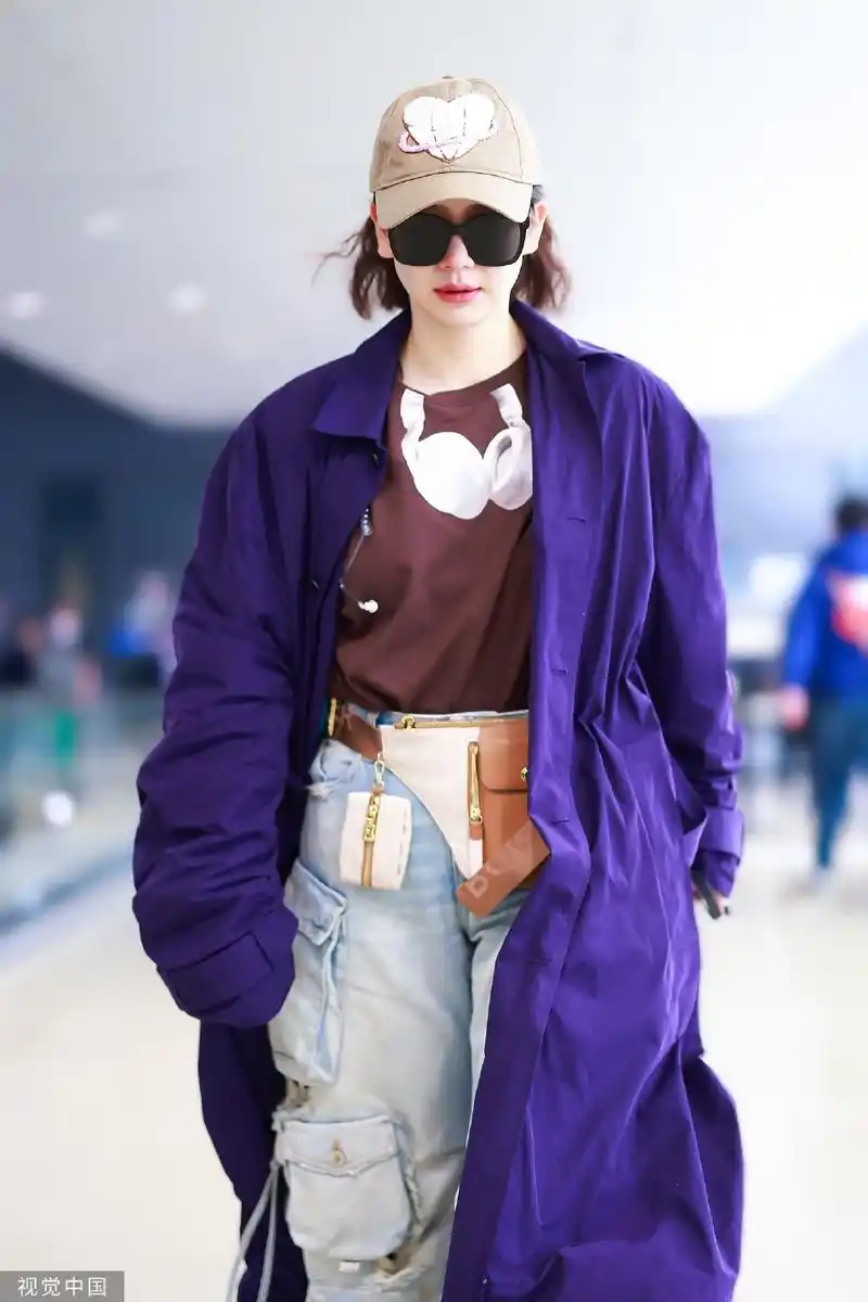 组图:戚薇穿搭时尚现身机场 紫色外套配工装裤酷拽随性