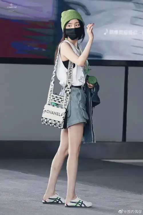 杨幂手里拿着莲蓬#杨幂今日机场出发饭拍,背心短裤绿色毛线帽,今天是