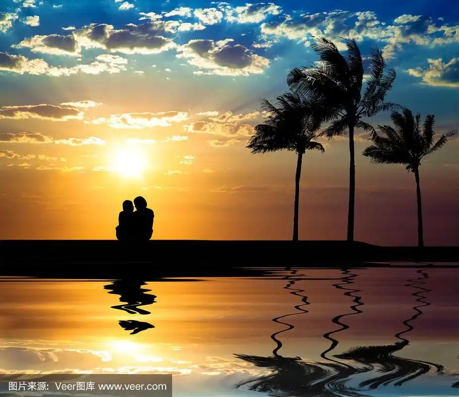 海滩上看日落的情侣剪影