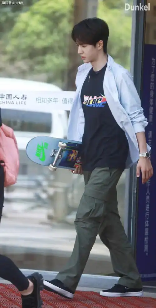 王一博身穿浅蓝色衬衫内搭黑色印花t恤,阳光时尚