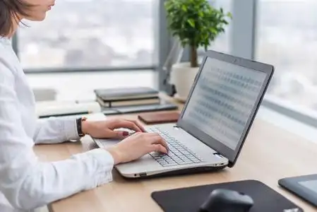 女商人在职场女人在笔记本电脑上打字工作在办公室手键盘照片