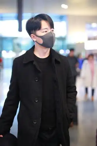 组图:黄轩素颜口罩遮面难掩帅气 全黑look造型独自拉行李接地气