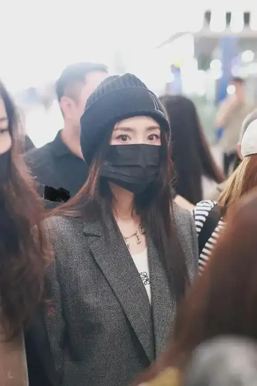 杨幂长发披肩,戴上黑色针织帽子,可爱乖巧,戴着黑色的口罩,神秘感爆棚
