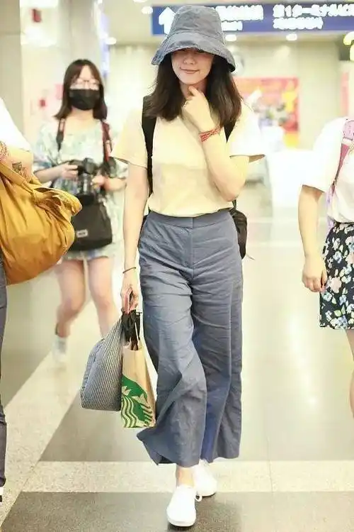 米色t恤的宽松设计让高圆圆看起来更加随和,而阔腿牛仔裤则巧妙地修饰