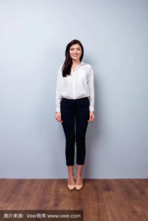 全身照片正面的年轻自信的女商人灰色背景