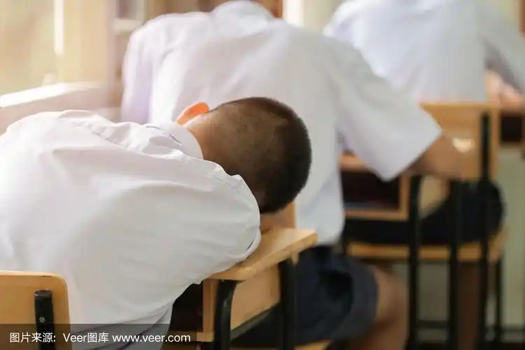排在亚洲男孩后面的学生穿着校服睡觉在教室里考试,教育学校,上课坐在