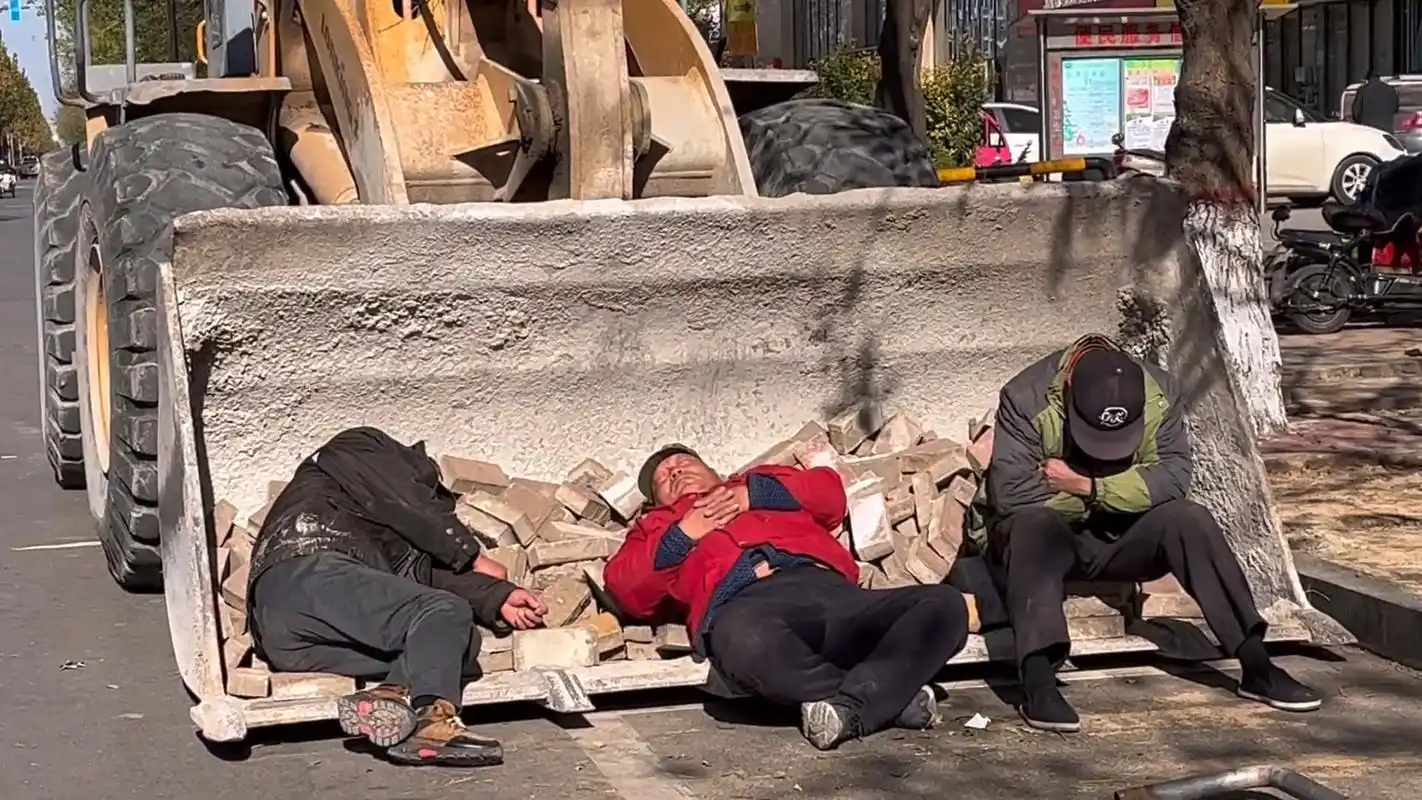 生活不易!三位农民工大叔在路边席地而睡.