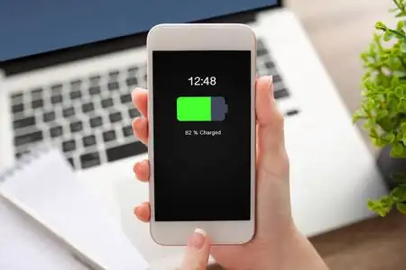 女手白色手机充电的电池在屏幕上照片