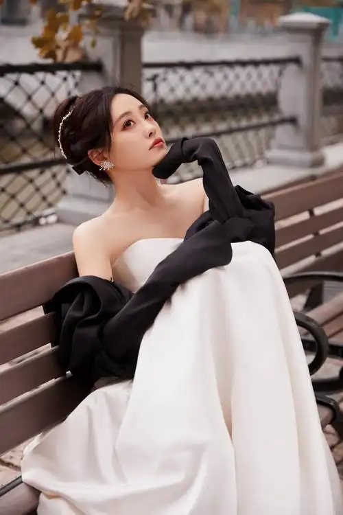 法国梧桐下,@祝绪丹bambi一袭白缎面墨色玫瑰礼服袅袅摇曳,漾开一抹