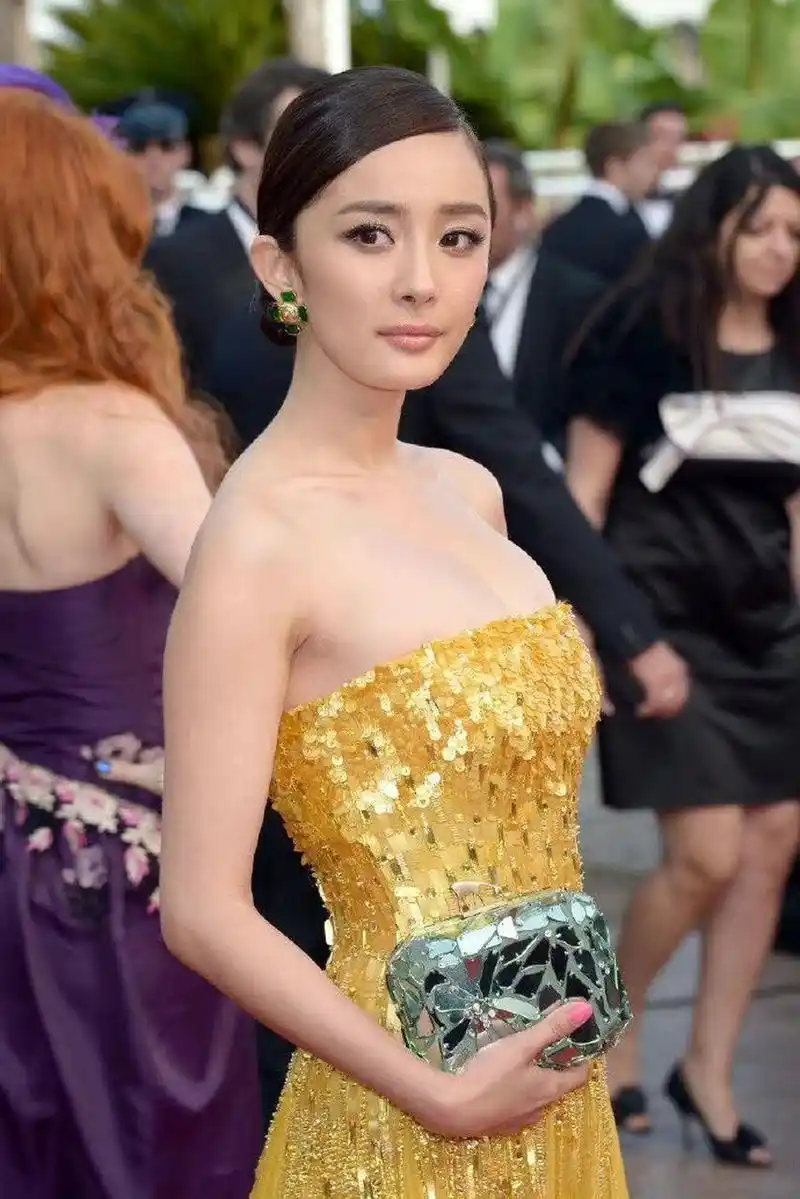 杨幂身穿露肩抹胸礼服,女人味爆棚  在照片中,杨幂身穿一件亮黄色的