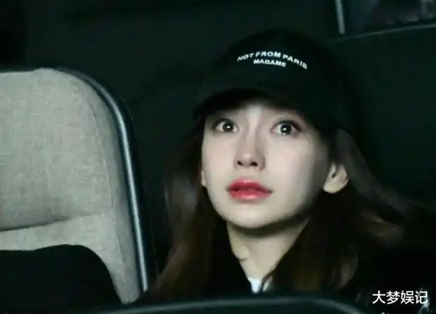 曝光照片中,她戴着鸭舌帽,口罩,素颜看起来神情憔悴,紧抱着孩子坐在