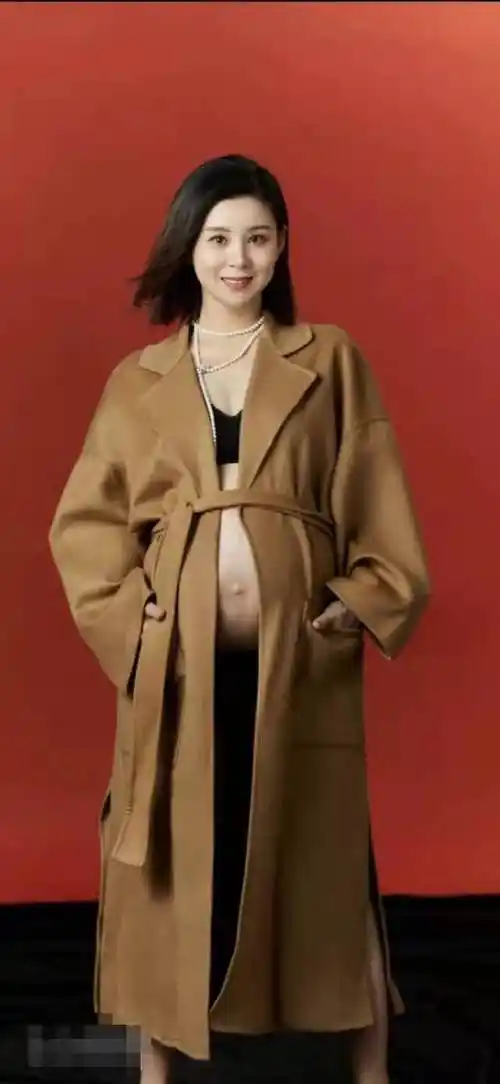 照片中的她穿了一件大褂子,隐隐约约可以看到她的大肚子非常的圆润,而