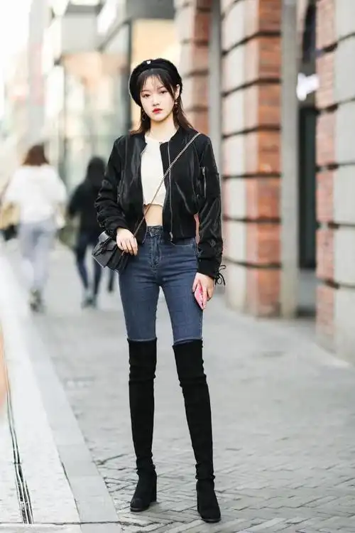 过膝的长筒靴搭配牛仔裤展现的身材很有魅力