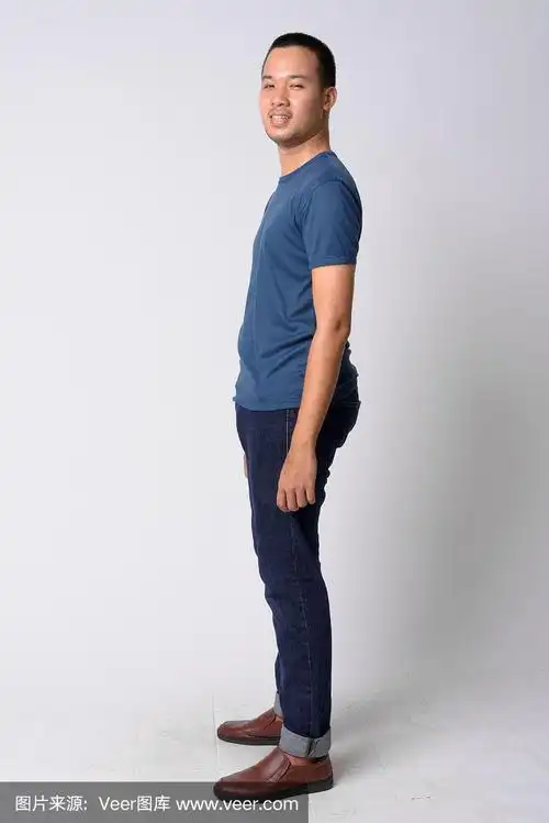 全身拍摄的侧面视图,快乐的年轻亚洲人看在相机