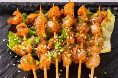 黑色盘里一串串的烧烤牛筋