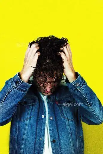 一个穿着蓝色牛仔夹克的男人抓着他的头发(man in blue denim jacket