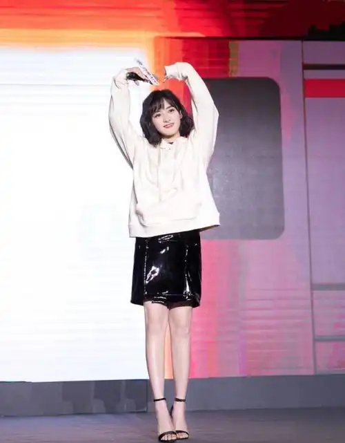 下身是一条黑色的半身裙,脚上则踩着一双黑色的高跟鞋,整体的搭配给人