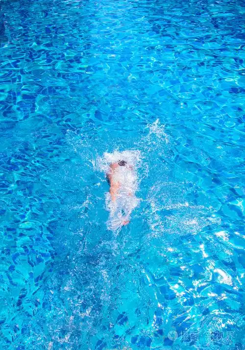 一个女孩在游泳池潜水的顶视图