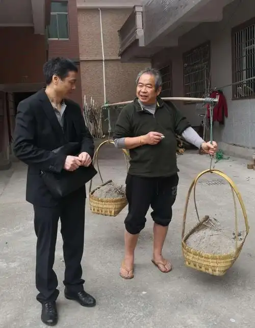 旅居西班牙的林献民先生拿着扁担,挑着畚箕出发去田间拔菜了.