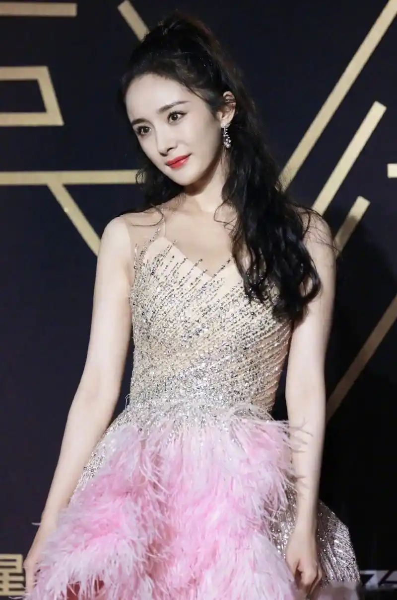 杨幂身着粉色羽毛不规则长裙亮相星光大赏红毯 ,将优美的肩颈线条尽展