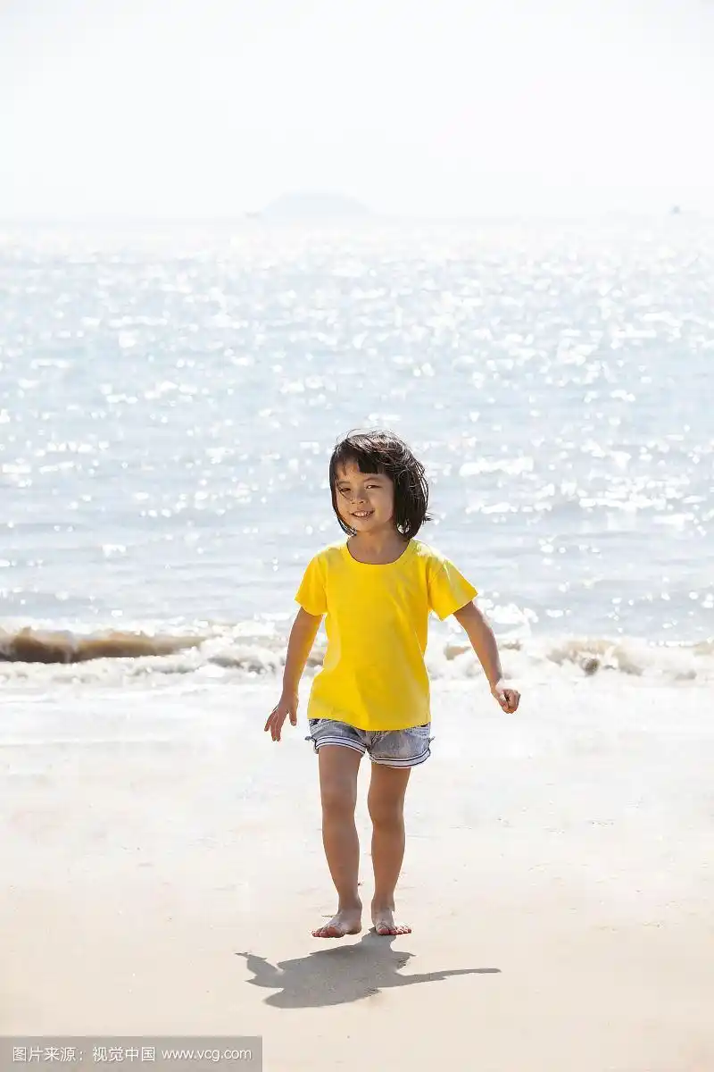 小女孩赤脚在沙滩上奔跑