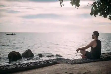 戴太阳镜的帅哥在日落时看着海洋上的地平线.照片