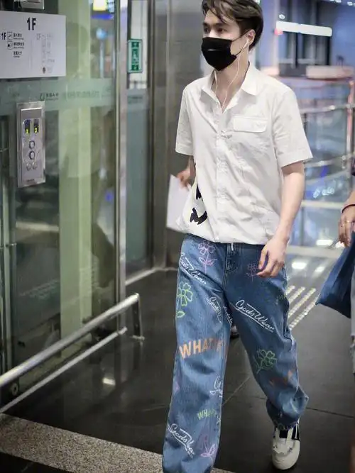 张艺兴今日机场饭拍分享,印花白衬衫搭配小花涂鸦设计牛仔裤,五官立体