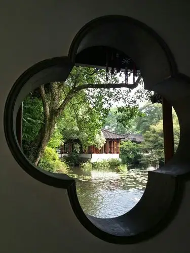 从花瓣形窗户朝里望去,一派江南私家园林景色呈现在眼前.