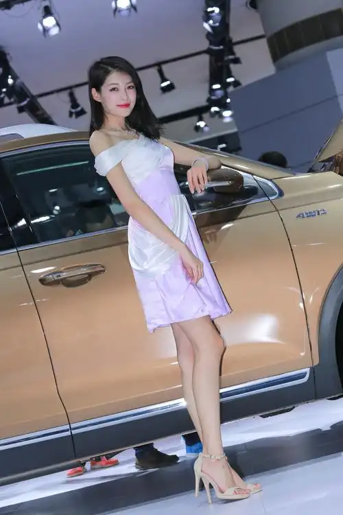 车展人像摄影:美丽的车模身材高挑,微笑可人,气质优雅