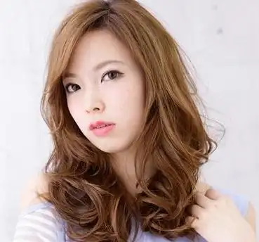 这是一位长脸形的额头窄的女生,长长的脸蛋,选择了侧分式的长卷发发型