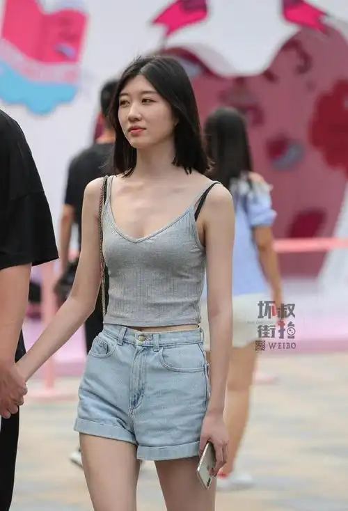 街拍小姐姐灰色吊带背心搭配牛仔短裤出街男友手牵着不放