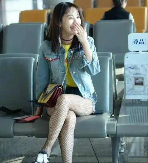 这样子的黑色渔网丝袜搭配上这样的牛仔短裤,让李菲儿的身材看起