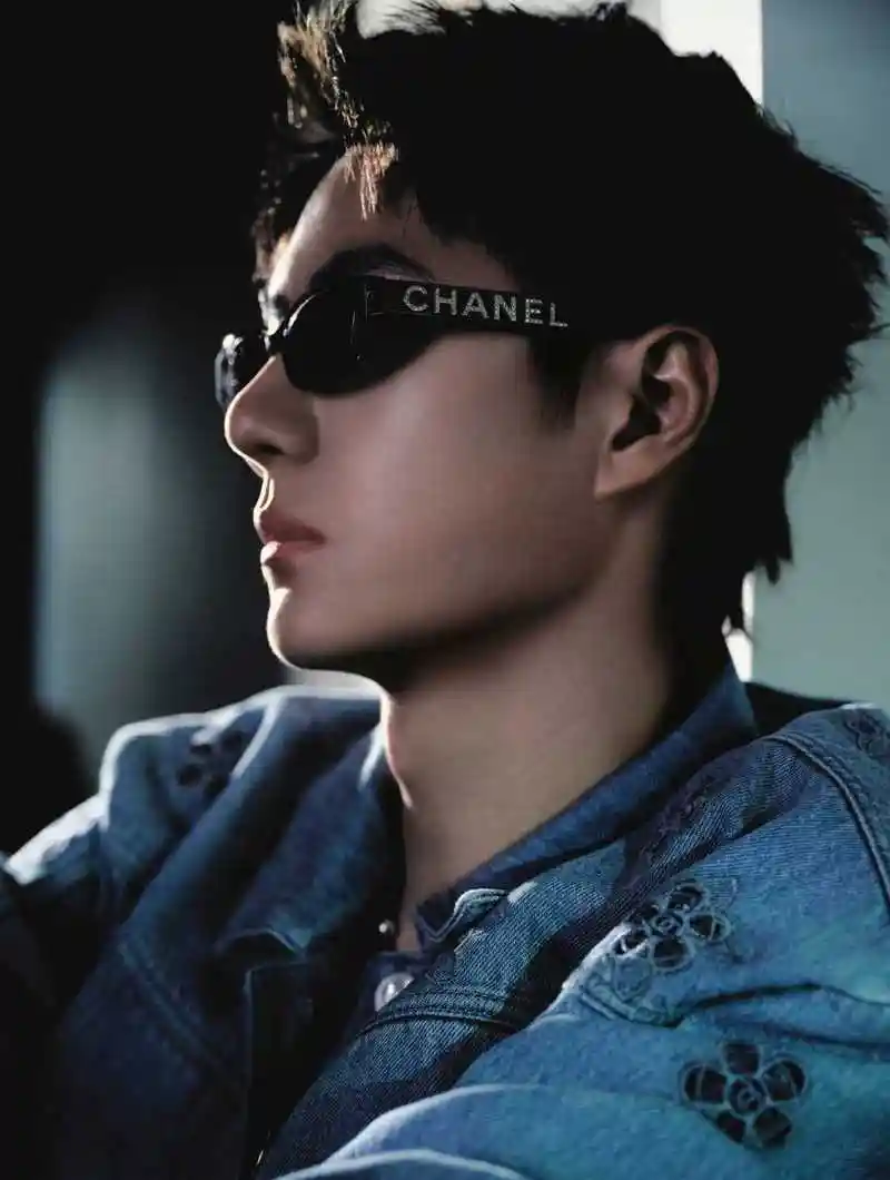 王一博身穿蓝色牛仔外套和长裤,搭配香奈儿墨镜.