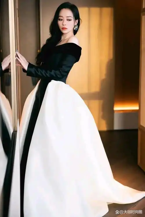 张靓颖身着一套典雅的黑色与纯粹的白色相间的礼服,展现出她独特的的