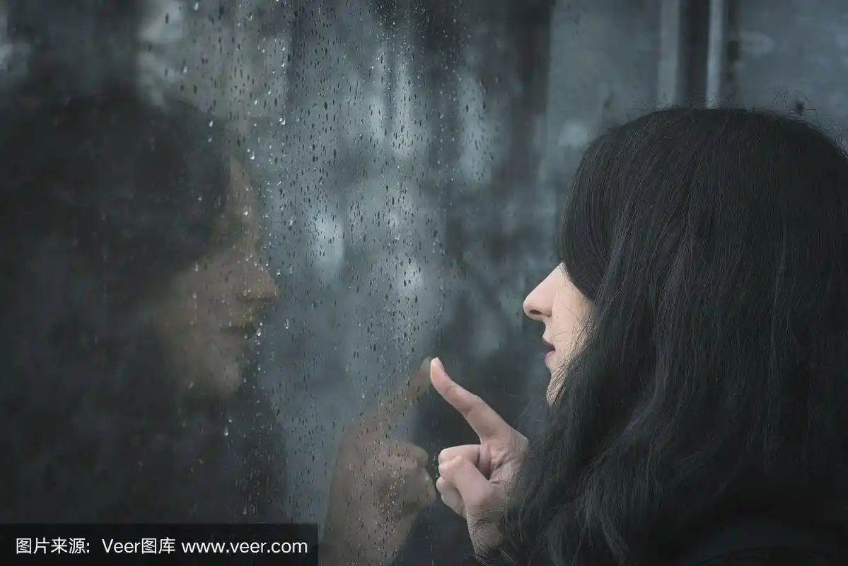 女人看着下雨的窗户