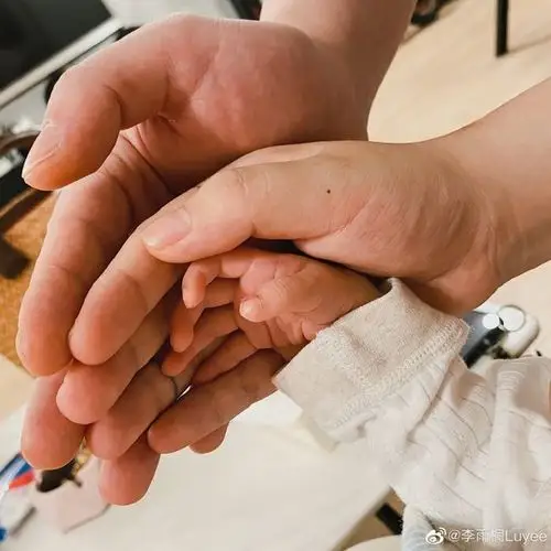 另一张照片中,李雨桐还晒出了一家三口将手叠放在一起的照片,三只