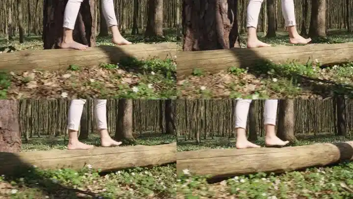一个女人赤脚在树干上行走