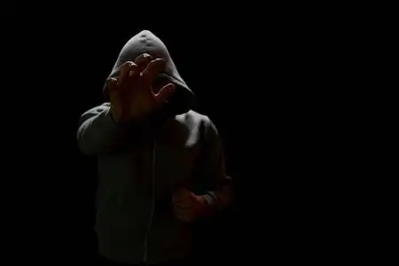 蒙面强盗伸出手去拿贵重物品照片