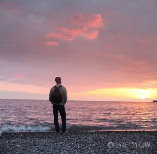 单独的人在海滩上看落日的温存